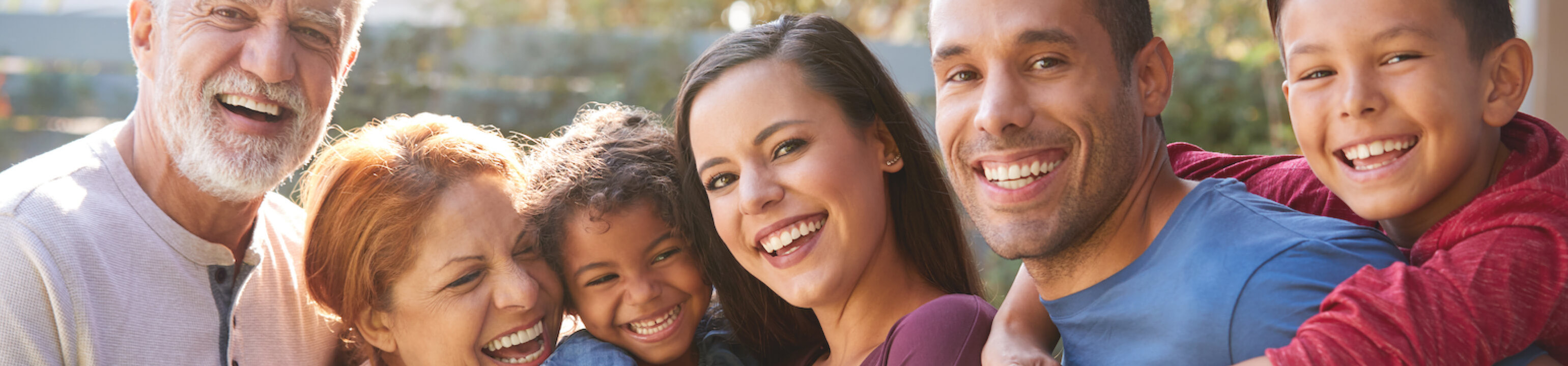 Group of multi-generation Hispanic family relaxing in garden at home together.